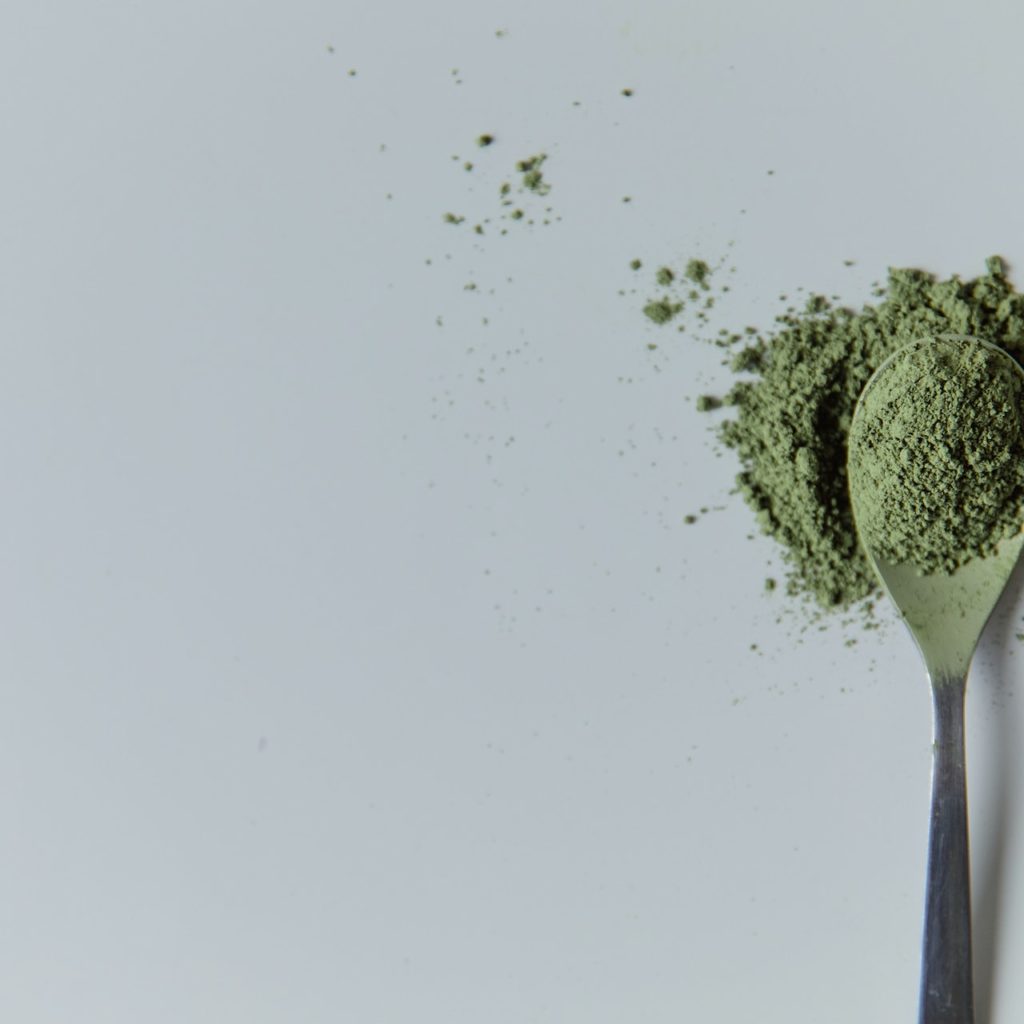 Spoon of green kratom powder
