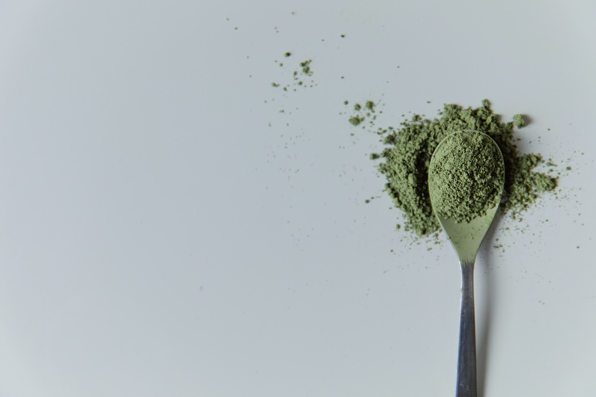 Spoon of green kratom powder